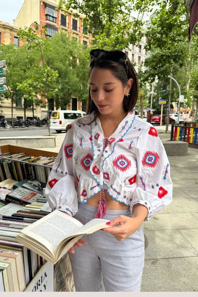 Esta blusa blanca de manga 3/4 combina la frescura del algodón con un diseño artesanal: delicados bordados que aportan textura tiene un pequeño pompón en el centro que añade un guiño divertido y único. Ligera, versátil y fácil de combinar, es perfecta para días soleados o looks relajados con estilo.
