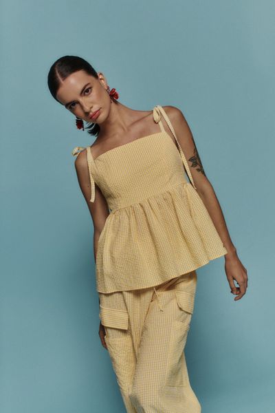 Top Citron Vichy Amarillo un toque de verano con estilo. El patrón vichy en tonos cítricos aporta frescura, los lazos regulables se adaptan a ti y el panal de abeja en la espalda suma textura y movimiento. Con cierre lateral que define la silueta, es la pieza perfecta para elevar tus looks de día a tarde sin esfuerzo.

XS
BUSTO: 84CM
ANCHO: 77CM
LARGO: 48CM

S
BUSTO: 87CM
ANCHO: 79CM
LARGO: 50CM

M
BUSTO: 90CM
ANCHO: 84CM
LARGO: 52CM

L
BUSTO: 93CM
ANCHO: 86CM
LARGO: 53CM
