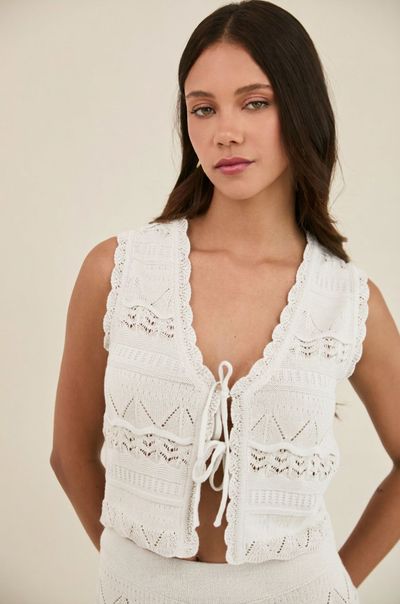 Texturas suaves, delicados detalles tejidos y una silueta relajada definen este chaleco atemporal. Diseñado con acabados ondulados y lazos frontales ajustables, es la prenda ideal para complementar y elevar tu outfit estilo resort. Combínalo con el pantalón a juego para lograr un look resort elegante.

 

Detalles


	Tejido premium de alta calidad
	Cierre frontal con lazos ajustables
	Acabados ondulados decorativos
	Tela liviana y transpirable
	Pantalón a juego disponible


 

TALLA S
Largo 45
Busto 82/ Expande hasta 87
Cintura 78/ Expande hasta 83
TALLA M
Largo 45
Busto 84/ Expande hasta 89
Cintura 80/ Expande hasta 85
TALLA L
Largo 45
Busto 86/ Expande hasta 91
Cintura 82/ Expande hasta 87
